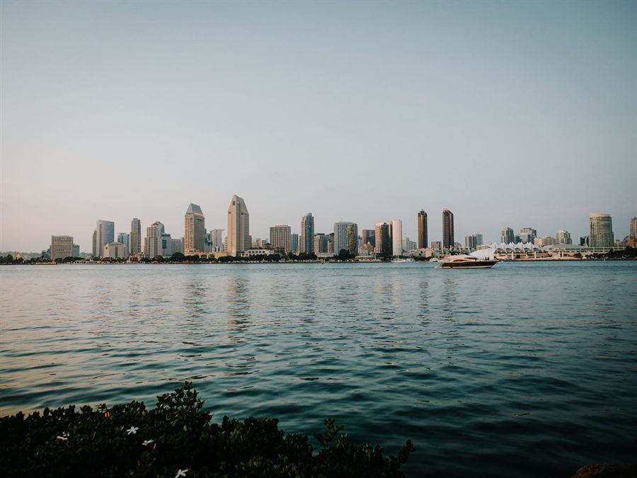 San Diego skyline across the bay with a yacht sailing past