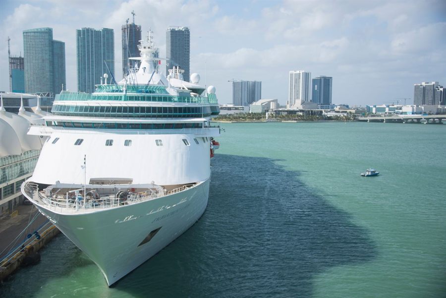 Cruise ship docked at the Port of Miami with the city skyline behind