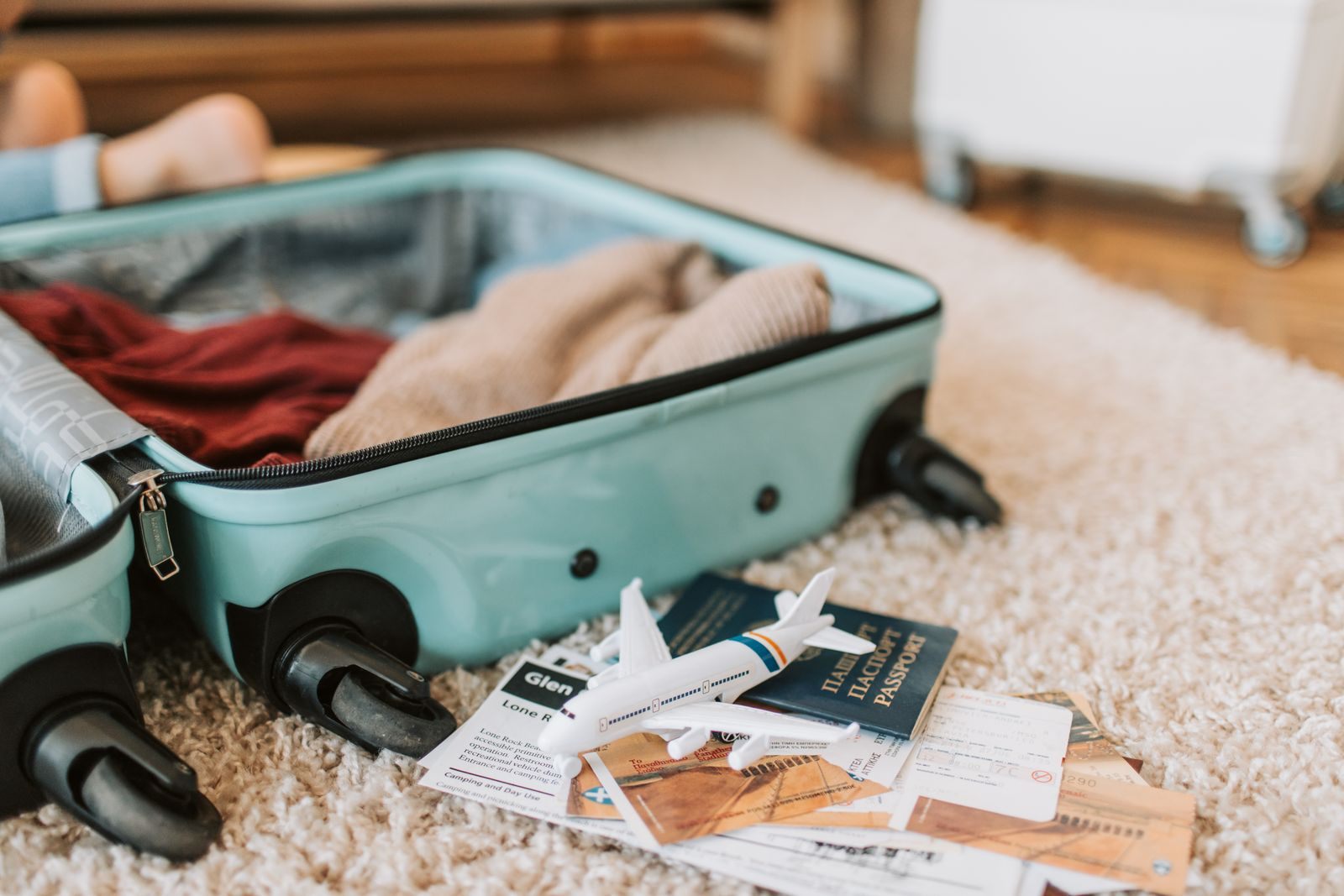 Open suitcase with passport and travel papers on the floor, ready for a cruise booked within 90 days