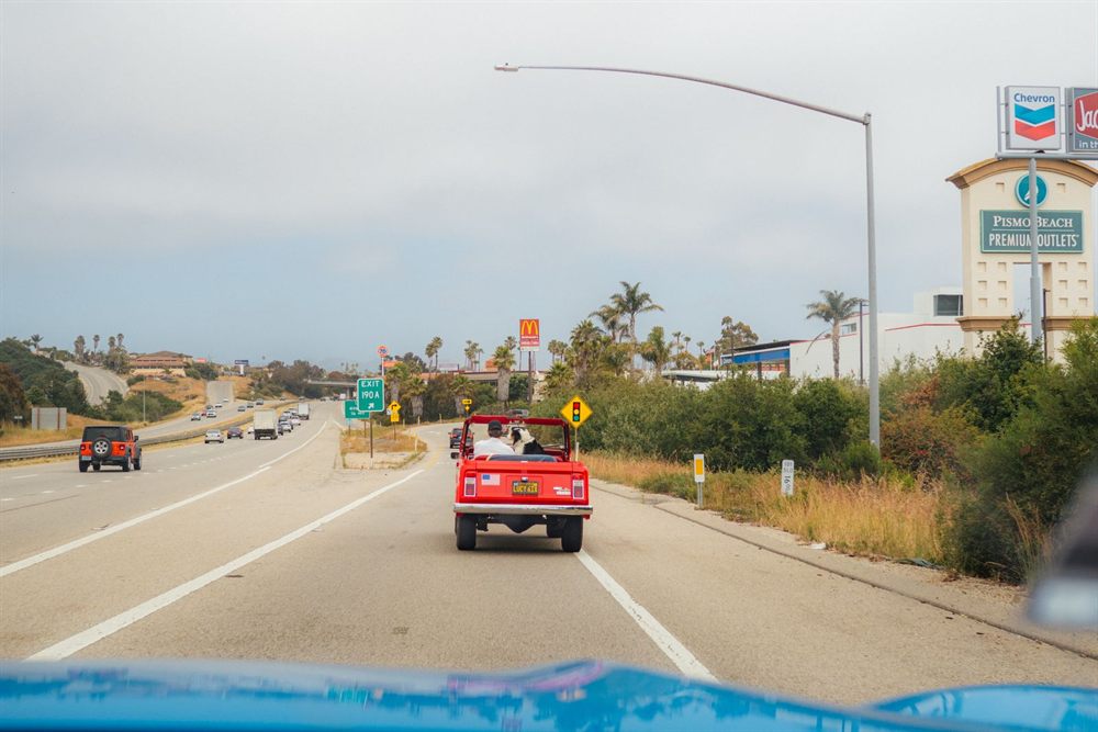 Red convertible driving along a California coastal highway